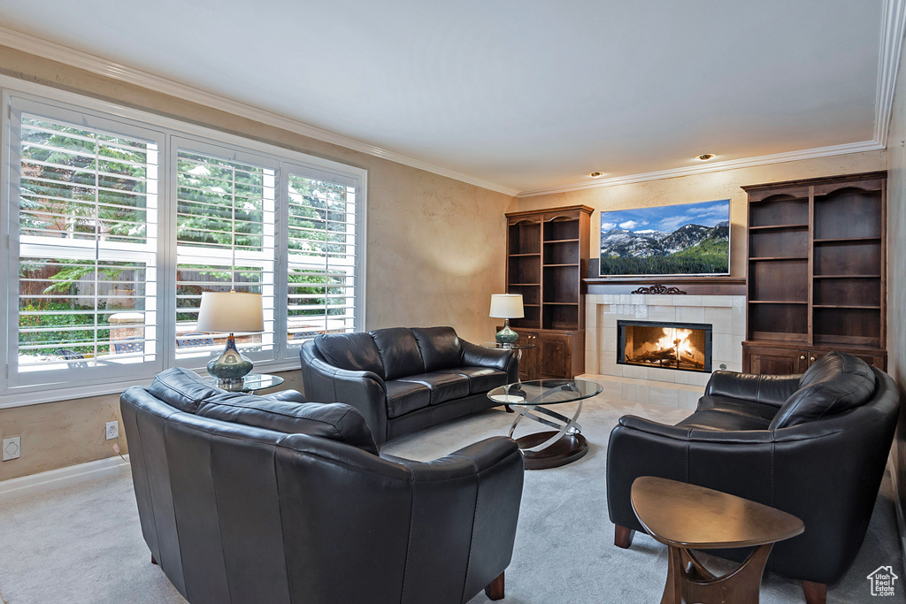 Living area featuring ornamental molding, a fireplace, carpet flooring, and baseboards