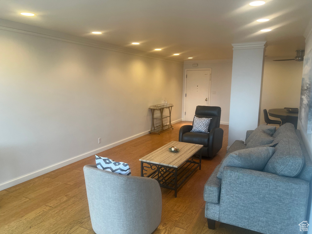 Living area featuring ornamental molding, wood finished floors, recessed lighting, and baseboards