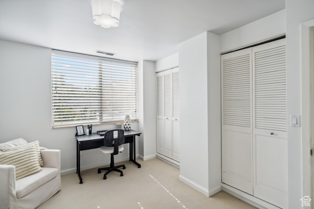 Home office featuring baseboards and light colored carpet