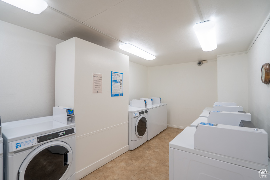 Shared laundry room featuring independent washer and dryer and baseboards
