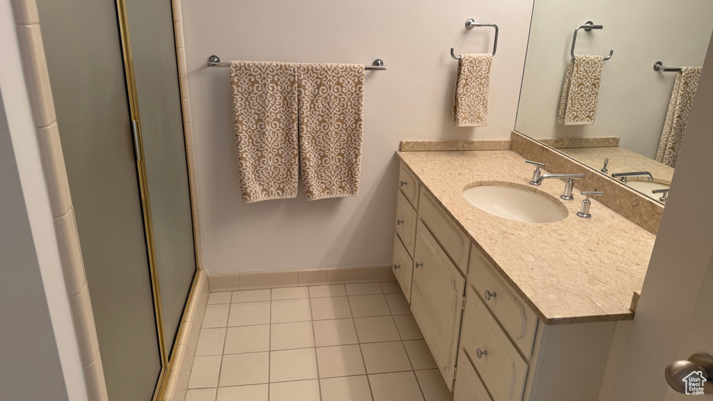 Full bathroom with a shower with door, tile patterned flooring, and vanity