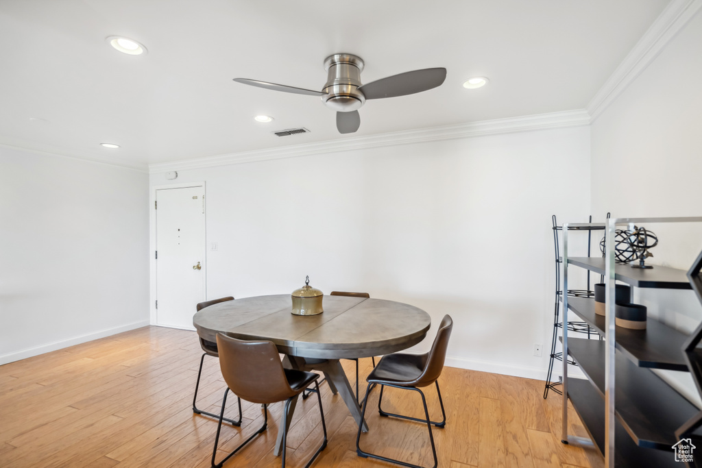 Dining area with crown molding, ceiling fan, light wood-style floors, and recessed lighting