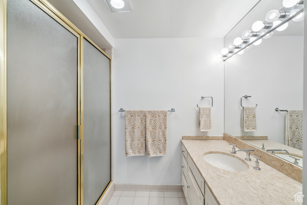 Full bath featuring vanity, a shower stall, and tile patterned flooring