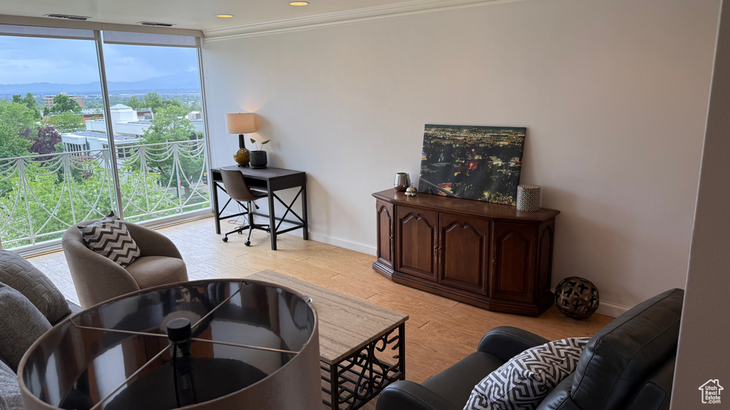 Living room with baseboards, healthy amount of natural light, crown molding, floor to ceiling windows, and a mountain view