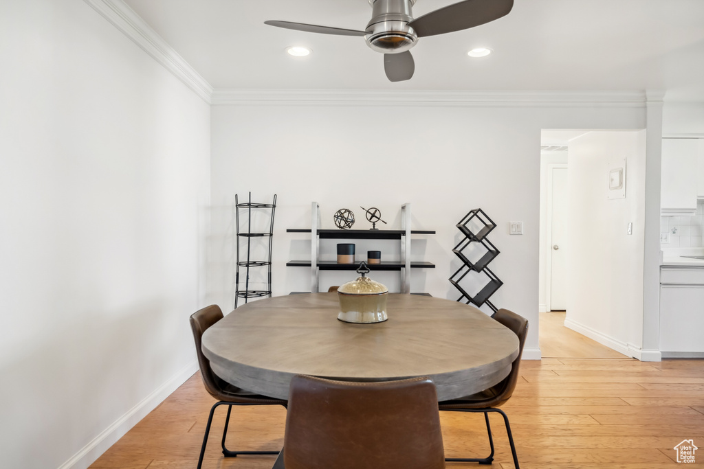 Dining space with ceiling fan, ornamental molding, light wood-type flooring, and recessed lighting