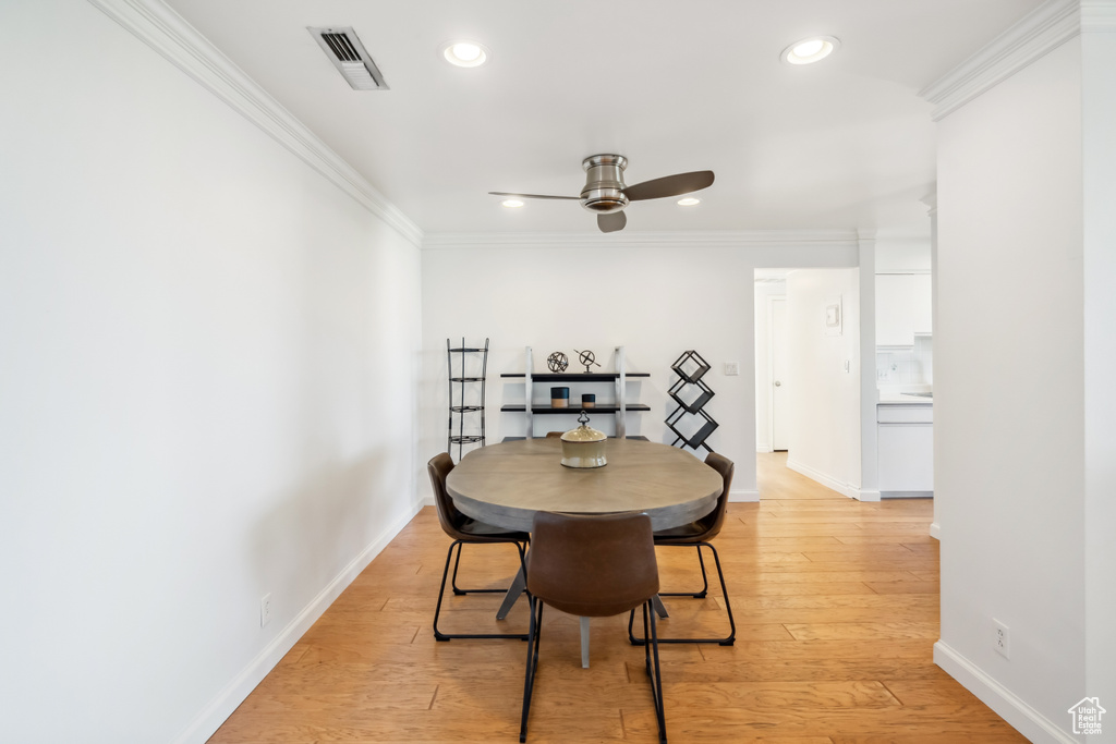 Dining room with a ceiling fan, ornamental molding, recessed lighting, and light wood-style floors