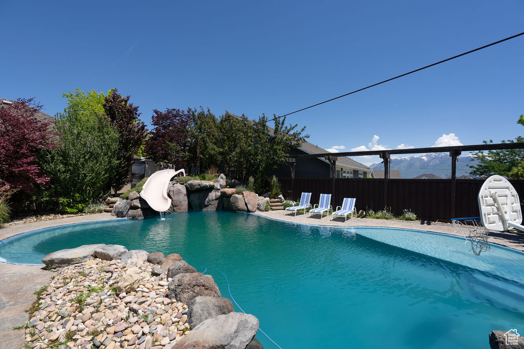 View of swimming pool with a water slide