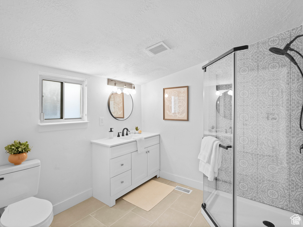 Bathroom with visible vents, toilet, a textured ceiling, vanity, and a shower stall