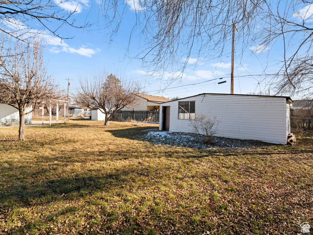 View of yard featuring an outbuilding and fence