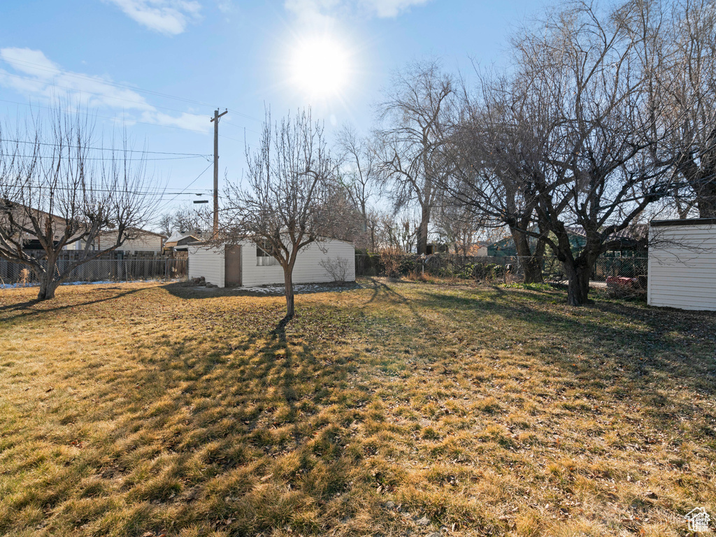 View of yard with fence and an outbuilding