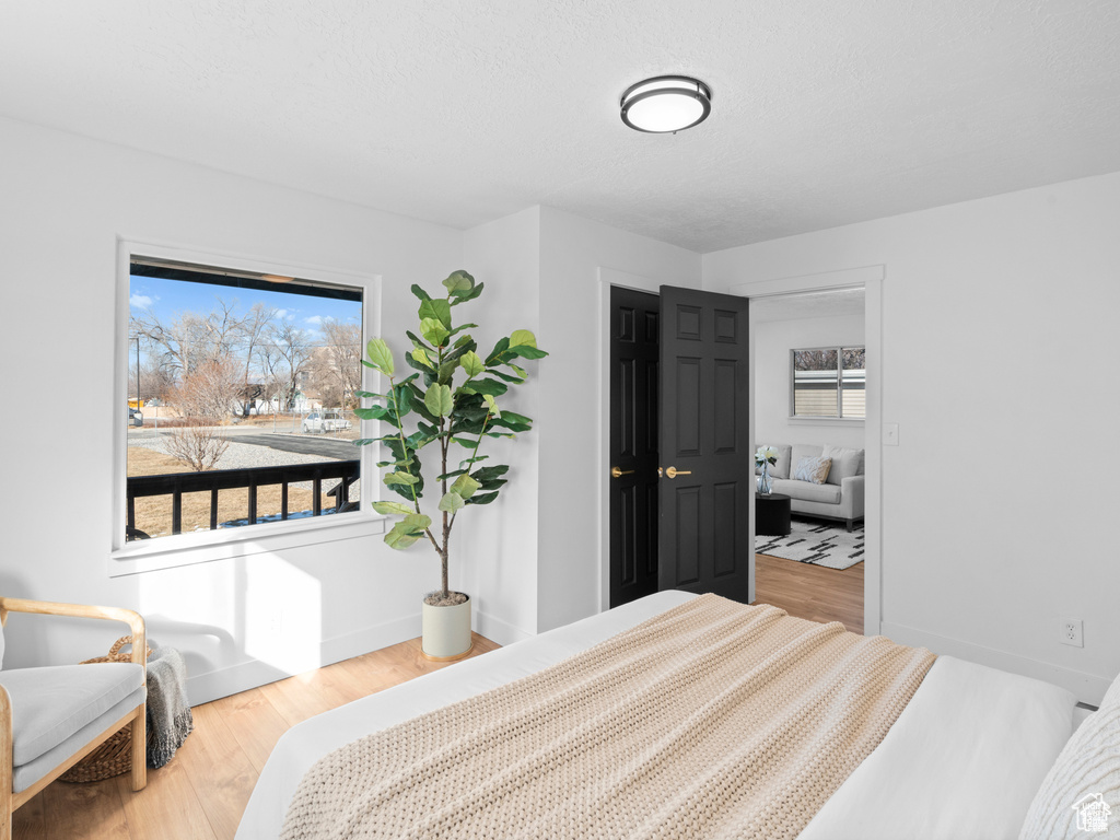 Bedroom featuring a textured ceiling, wood finished floors, and baseboards