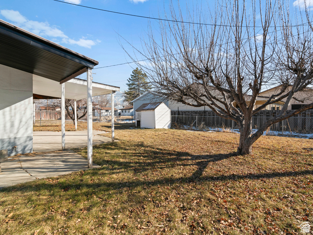 View of yard featuring a shed, fence, a patio, and an outdoor structure