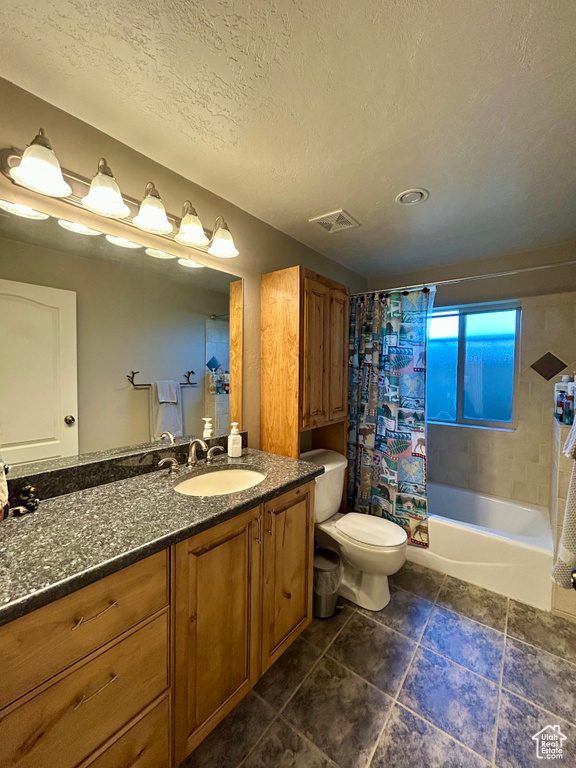 Full bath featuring vanity, toilet, a textured ceiling, shower / tub combo, and visible vents
