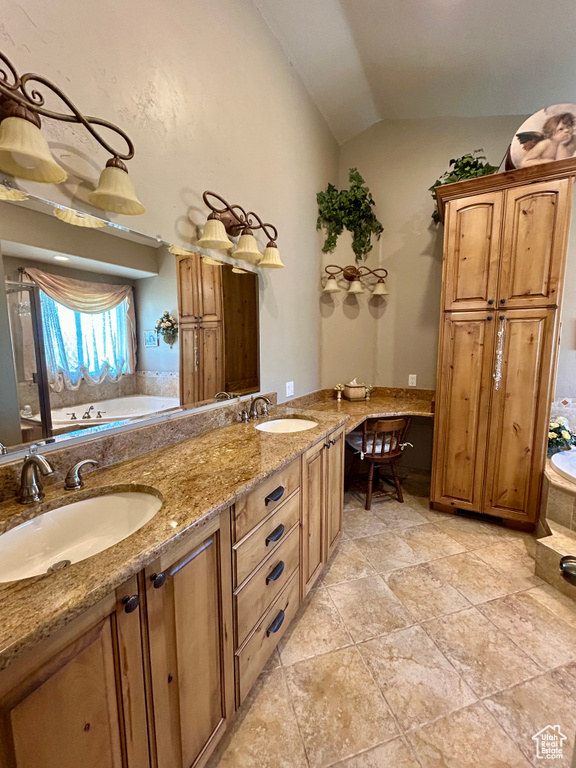 Full bathroom featuring a garden tub, a sink, lofted ceiling, and double vanity