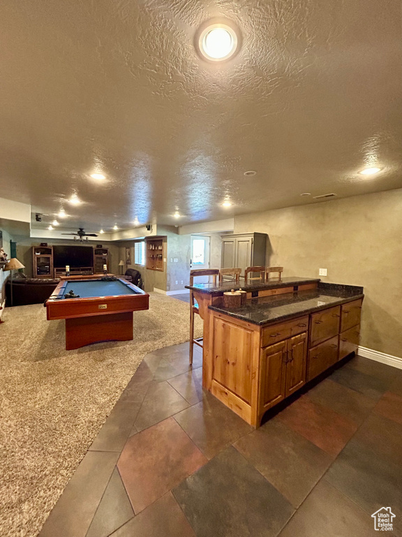 Recreation room featuring dark tile patterned flooring, baseboards, billiards, and a textured ceiling