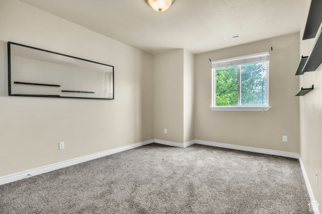 Unfurnished room featuring carpet and baseboards