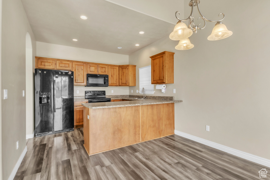 Kitchen with black appliances, baseboards, a sink, a peninsula, and recessed lighting