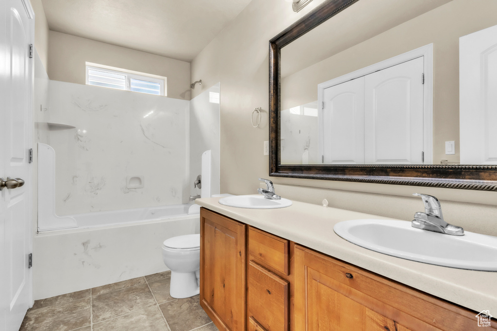 Full bath featuring double vanity, toilet, and shower / bathtub combination