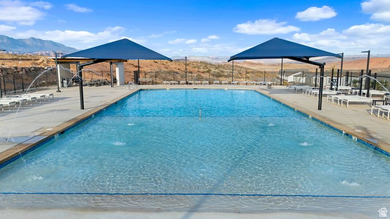 Pool with a mountain view, fence, and a patio area