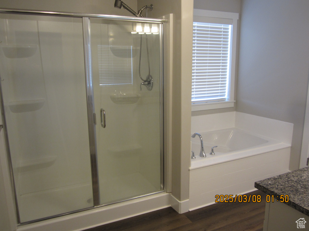 Full bath with a bath, wood finished floors, a shower stall, and vanity