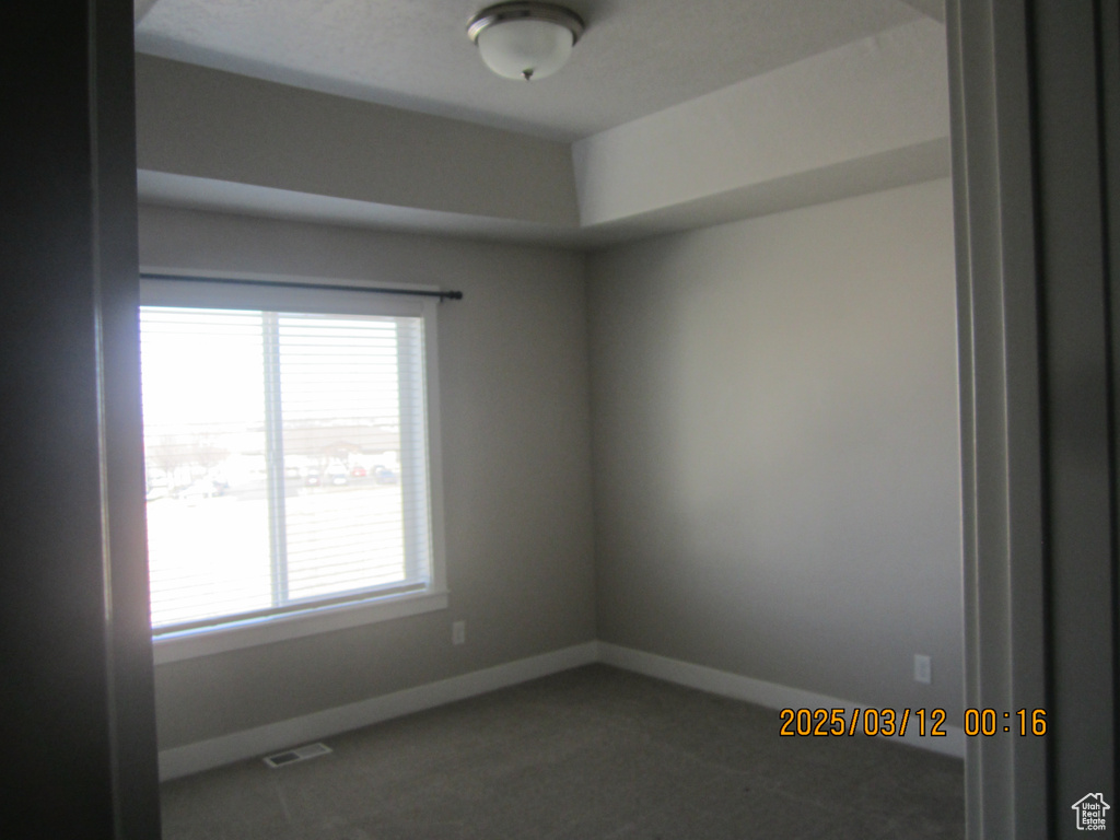 Spare room featuring visible vents, carpet, and baseboards