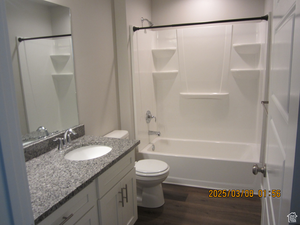 Full bath featuring shower / bathtub combination, vanity, toilet, and wood finished floors