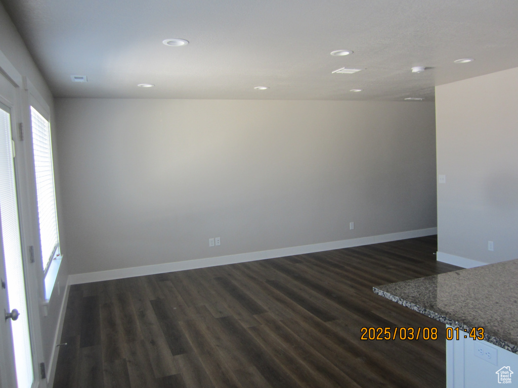Empty room with baseboards, dark wood-type flooring, and recessed lighting