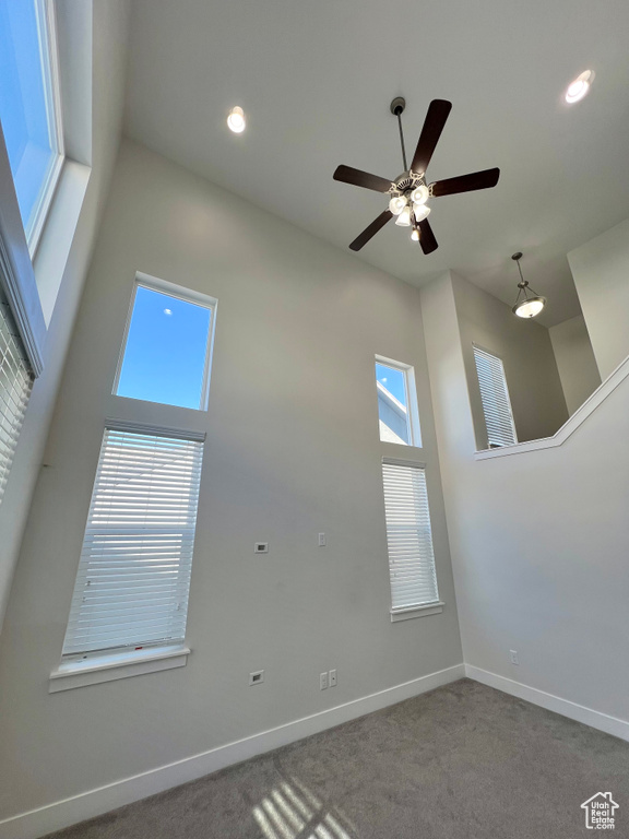 Carpeted empty room featuring recessed lighting, a high ceiling, and baseboards