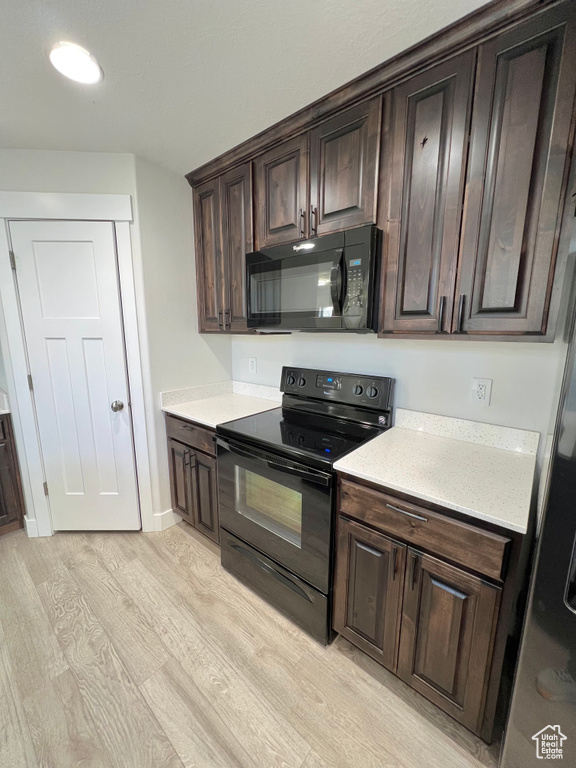 Kitchen with light wood-type flooring, black appliances, baseboards, and dark brown cabinets
