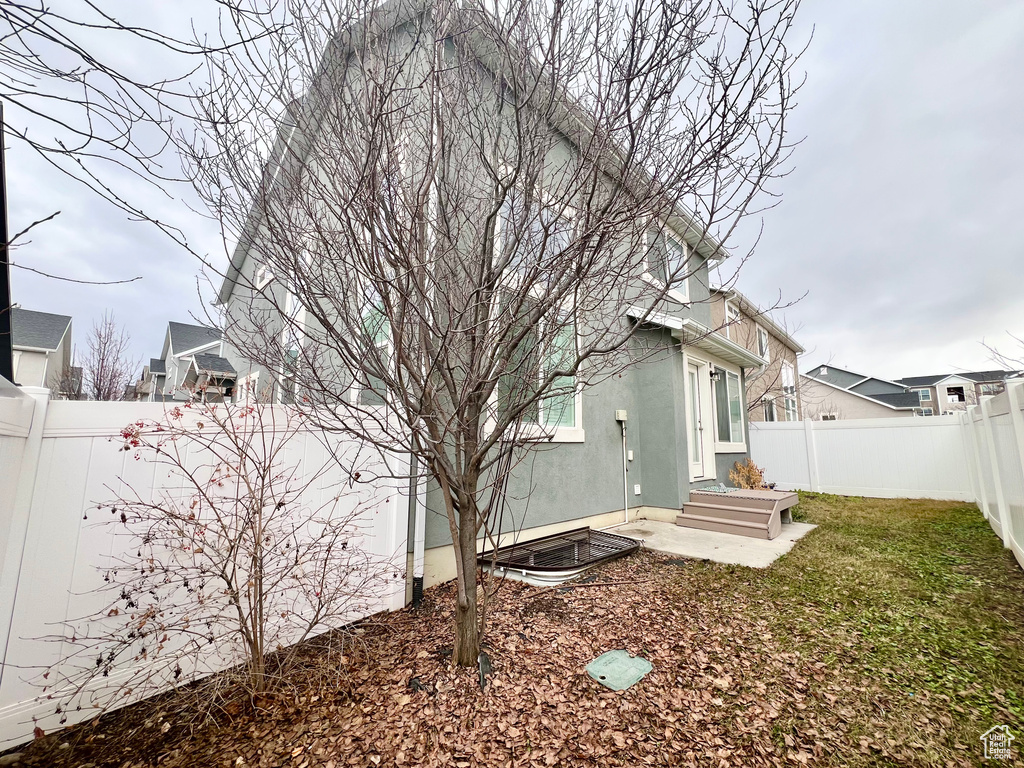 Rear view of house featuring a fenced backyard and stucco siding