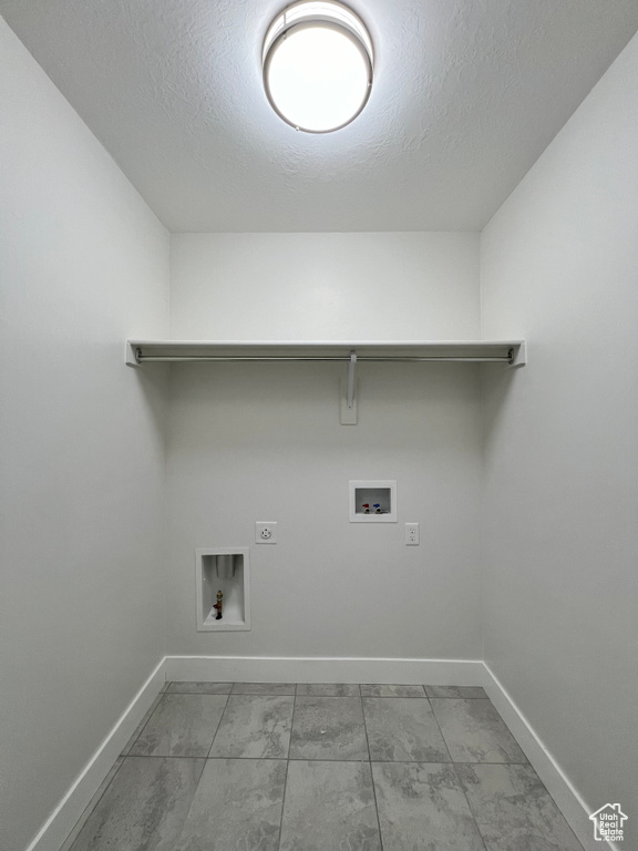 Laundry area with laundry area, baseboards, hookup for a washing machine, marble finish floor, and hookup for an electric dryer