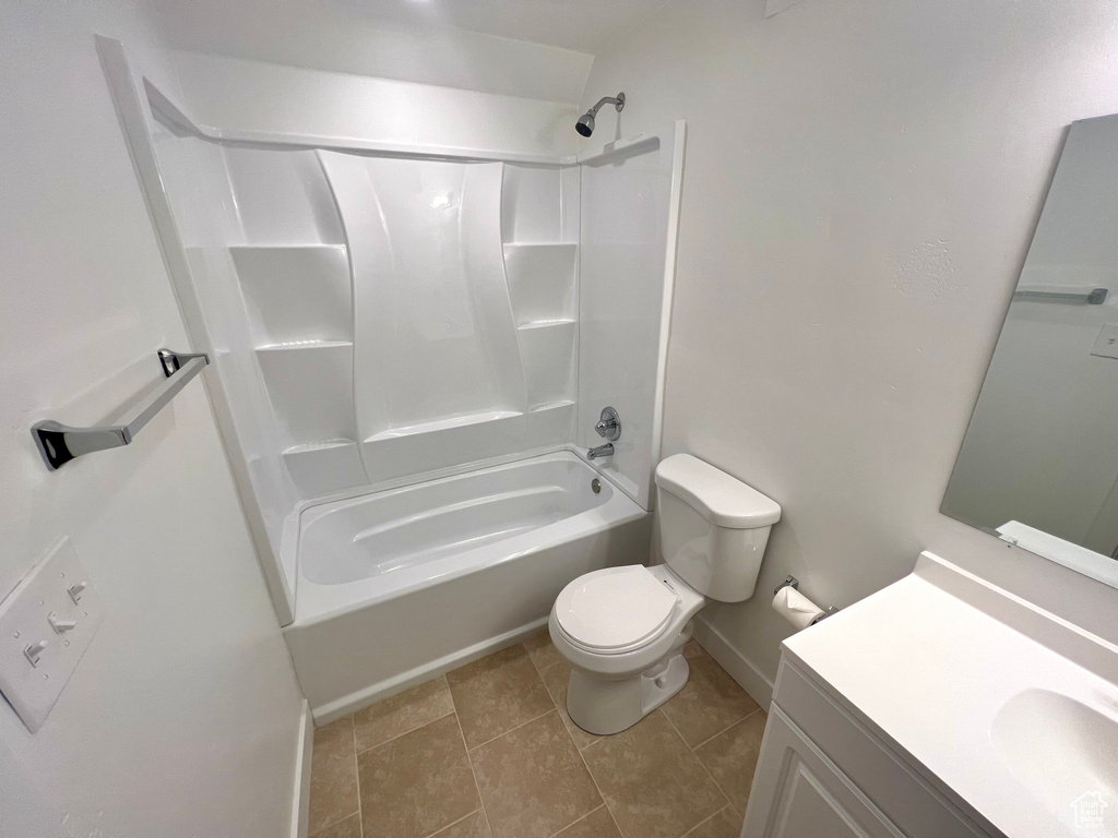 Bathroom with shower / bathtub combination, toilet, vanity, tile patterned flooring, and baseboards