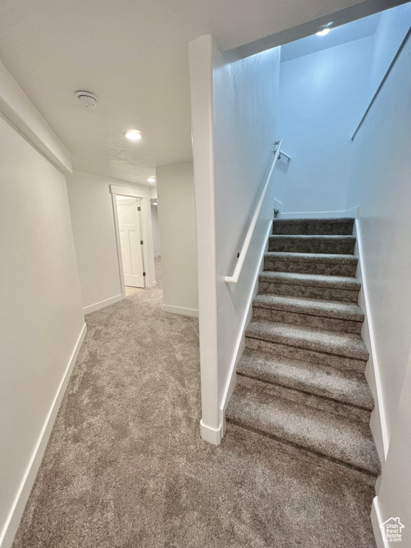Stairs featuring carpet, baseboards, and recessed lighting