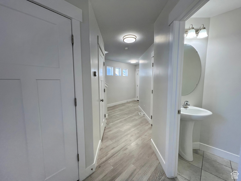 Bathroom with a sink, wood finished floors, and baseboards