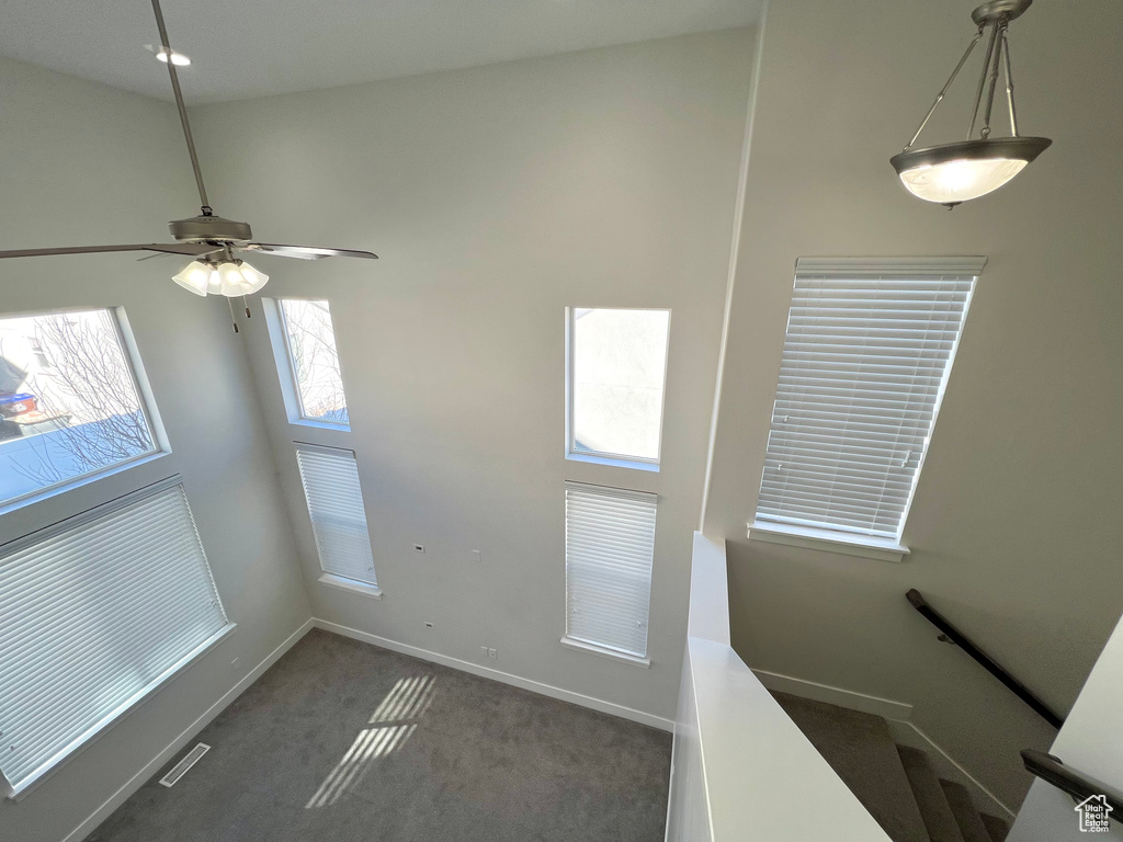 Interior space featuring a ceiling fan, baseboards, visible vents, and carpet flooring