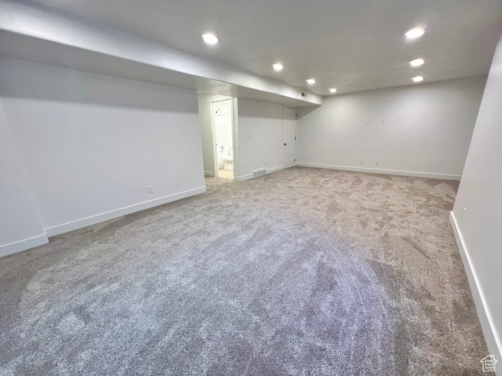 Finished below grade area with recessed lighting, carpet flooring, visible vents, and baseboards