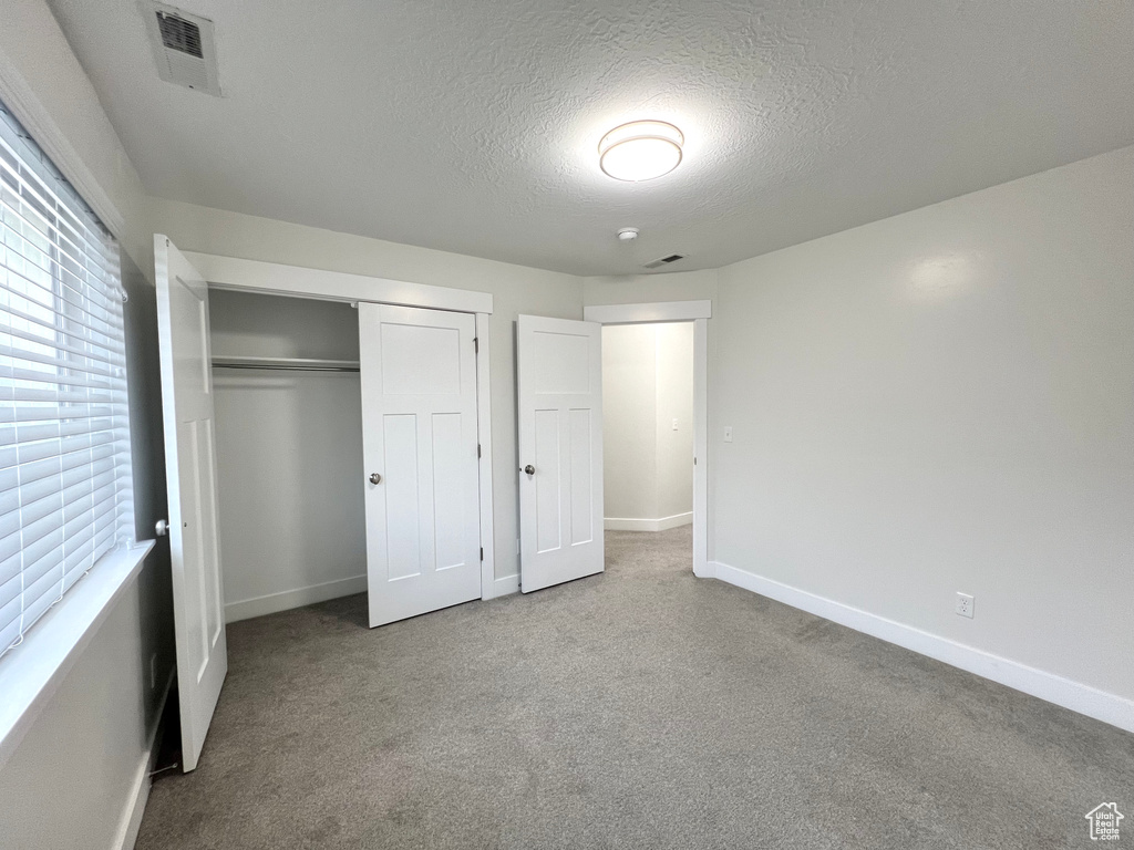 Unfurnished bedroom featuring baseboards, a closet, visible vents, and carpet flooring