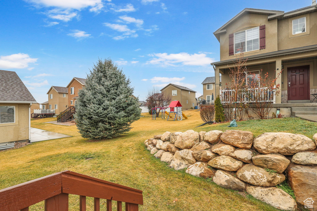 View of yard with covered porch and a residential view