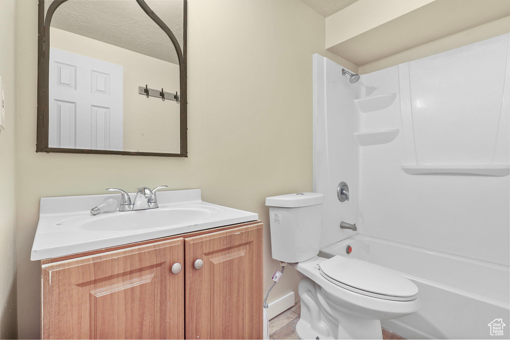 Full bathroom with shower / bathtub combination, a textured ceiling, vanity, and toilet