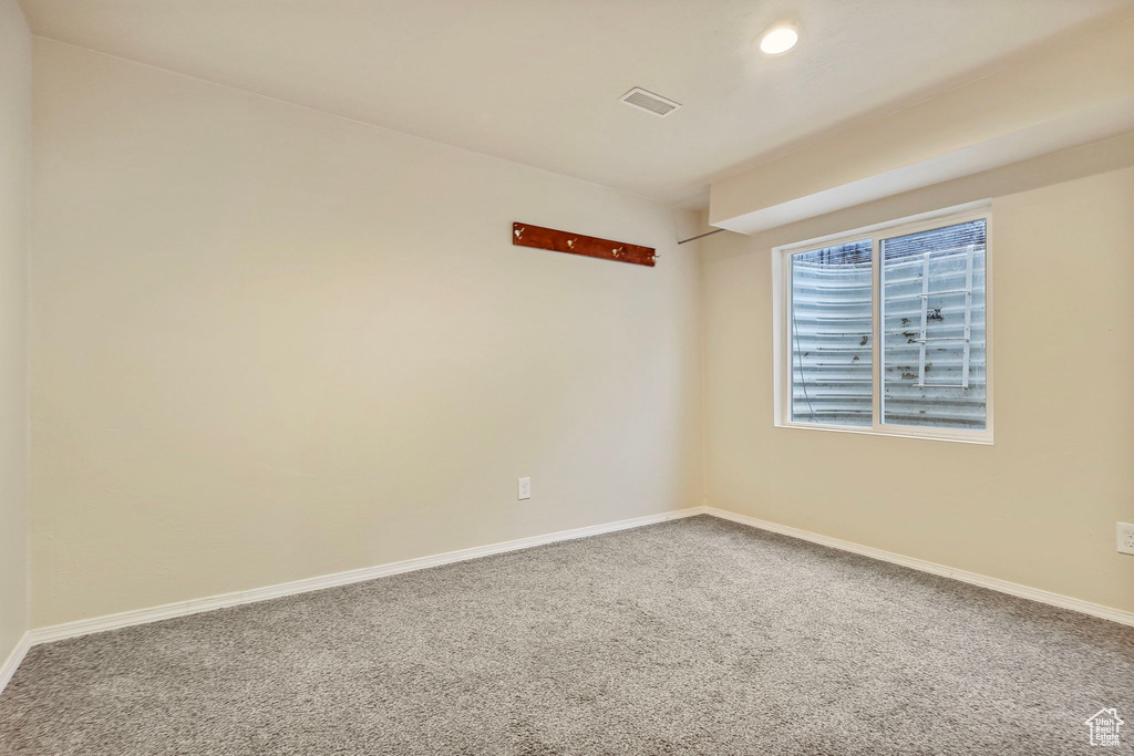 Unfurnished room with visible vents, baseboards, carpet flooring, and recessed lighting