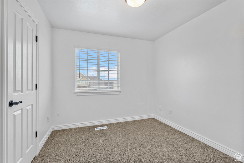 Unfurnished bedroom with carpet flooring, visible vents, and baseboards