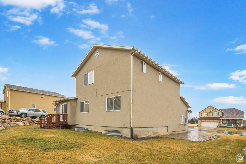 View of property exterior with stucco siding and a yard