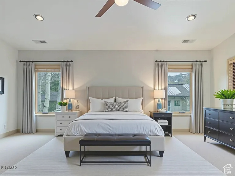 Carpeted bedroom featuring multiple windows, recessed lighting, and a ceiling fan