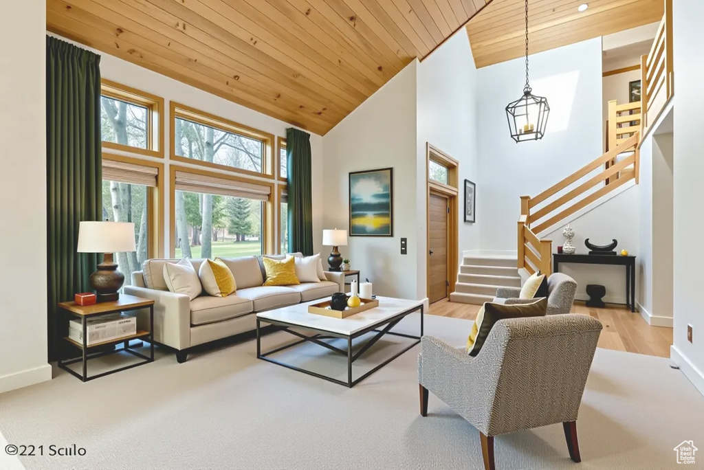 Living area featuring wood ceiling, stairs, high vaulted ceiling, wood finished floors, and a chandelier