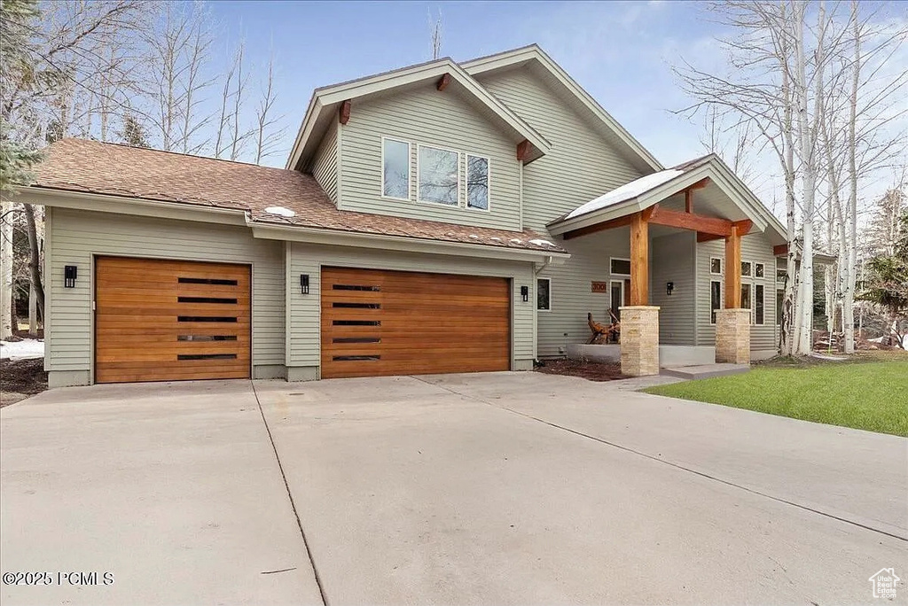 View of front of property with concrete driveway and an attached garage