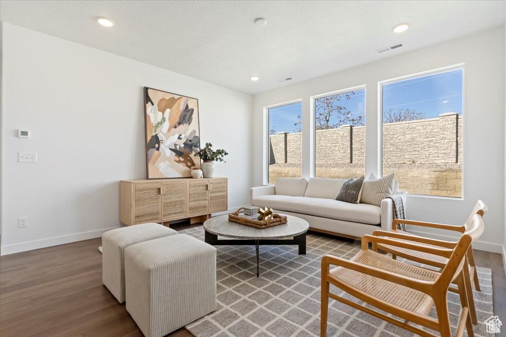 Living area with wood finished floors, recessed lighting, baseboards, and visible vents
