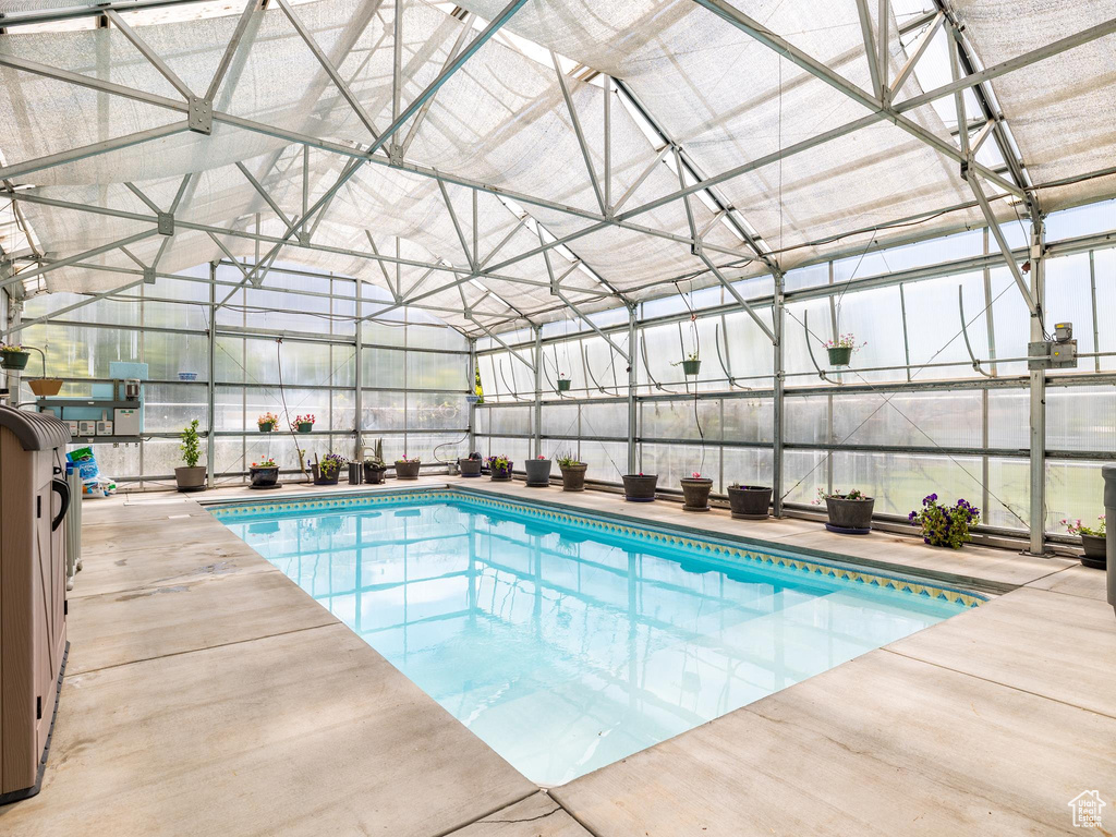 Indoor pool featuring glass enclosure and a patio area