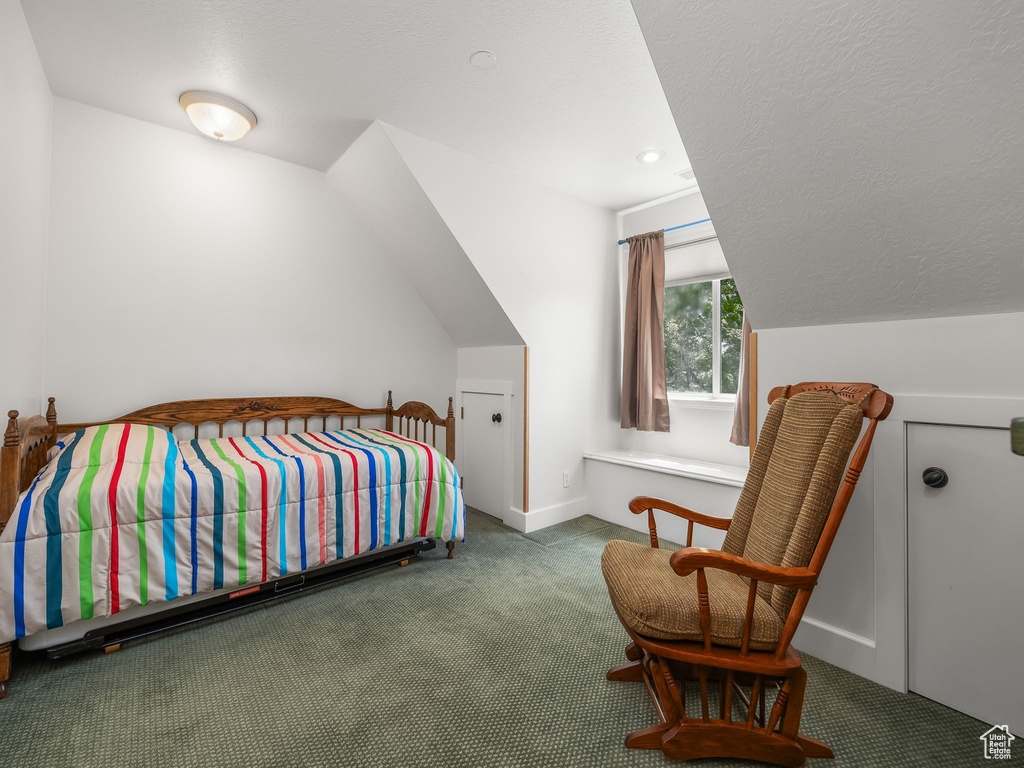 Bedroom with carpet floors, lofted ceiling, and baseboards