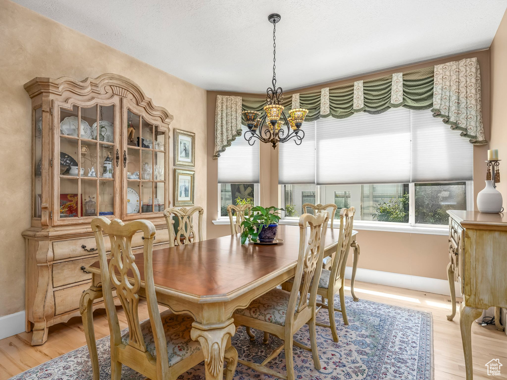 Dining room featuring a chandelier, light wood finished floors, and baseboards