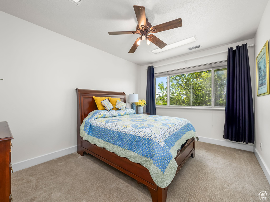 Bedroom with carpet, baseboards, and a ceiling fan